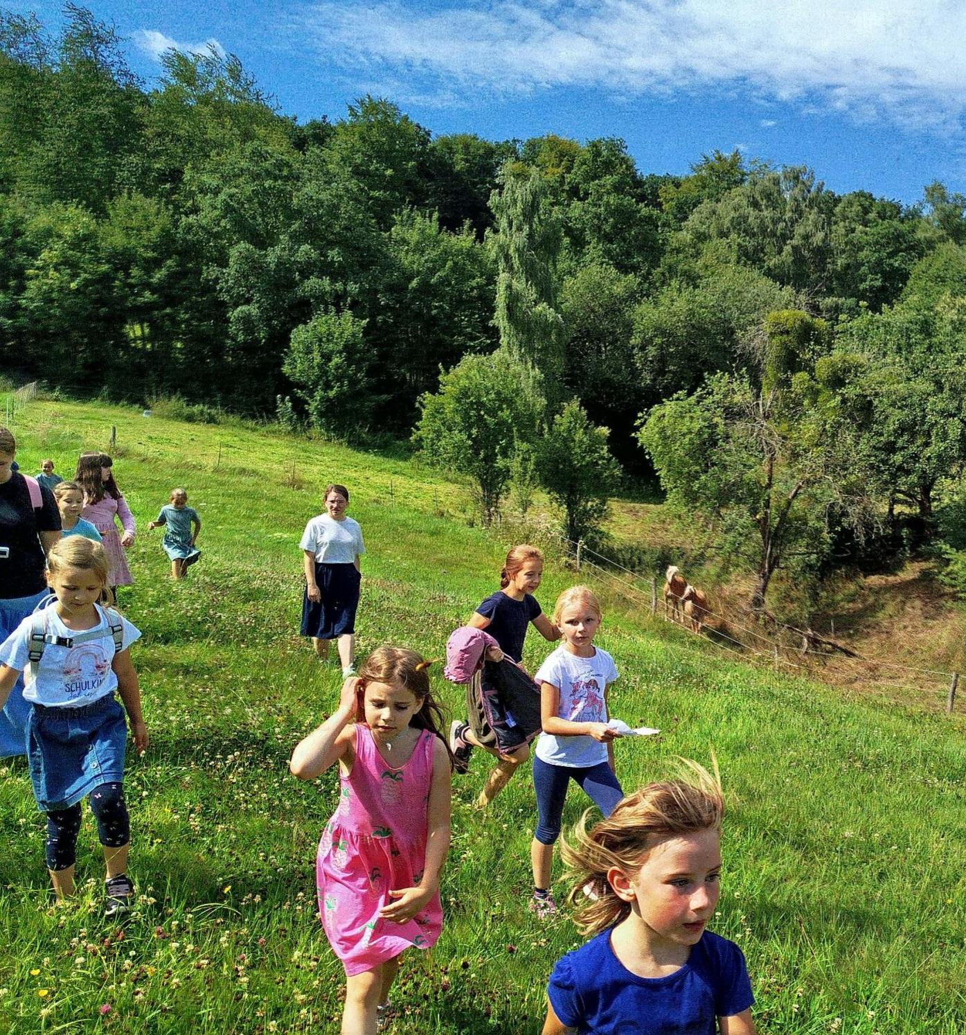 Kinder laufen fröhlich auf einer Wiese